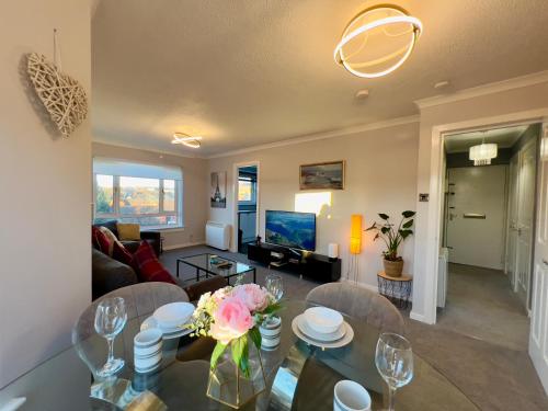 un soggiorno con tavolo in vetro con fiori di Chic & Cozy 2-Bed Flat in Glasgow - Free Parking a Glasgow
