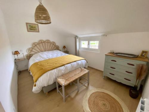 a bedroom with a bed and a dresser with a yellow blanket at Les Hauteurs du Trieux in Quemper-Guézennec