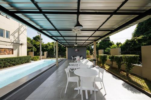 a patio with tables and chairs next to a pool at Tachang Airport Hotel in Hat Yai