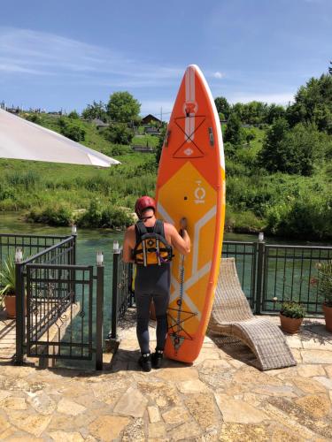 a man is standing next to a surfboard at Sokograd Royal in Šipovo