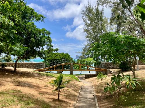 a wooden bridge over a body of water with trees at sea beach pool in Bain Boeuf