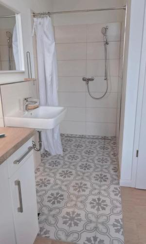 a bathroom with a sink and a shower at FeWo 1 Zimmer Apartment barrierefrei in Berne in Berne