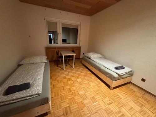 ハノーファーにあるApartment with three rooms and balconyのデスク、窓が備わるドミトリールームのベッド2台分です。