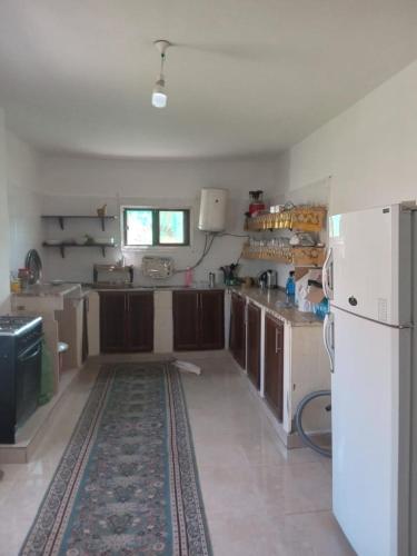 a kitchen with a white refrigerator and a counter at Leith Holiday Home in ‘Ayn Jannā