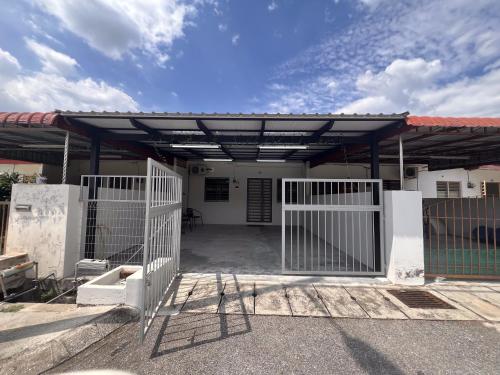 a gate to a house with a roof at Urban Eats Stay in Ipoh