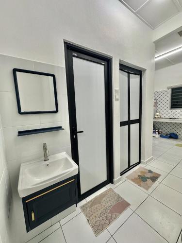 a white bathroom with a sink and a mirror at Urban Eats Stay in Ipoh
