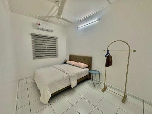 a white bedroom with a bed and a blue stool at Urban Eats Stay in Ipoh