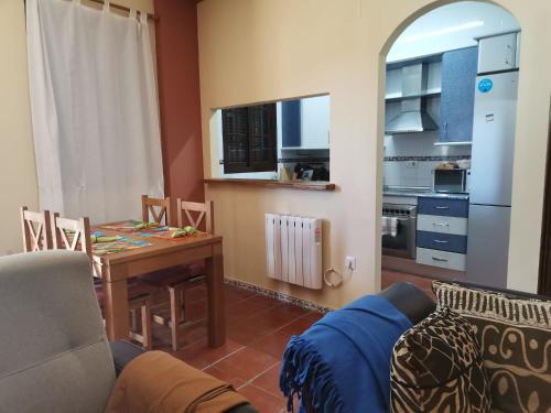 a living room with a table and a kitchen at Casa rural Isabel, en Sierra de Grazalema in Benaocaz