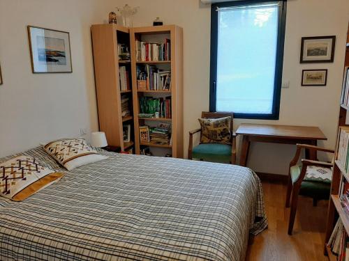 une chambre avec un lit, un bureau et une fenêtre dans l'établissement Le jardin de la Baie-face plage du Trez & thalasso, à Bénodet