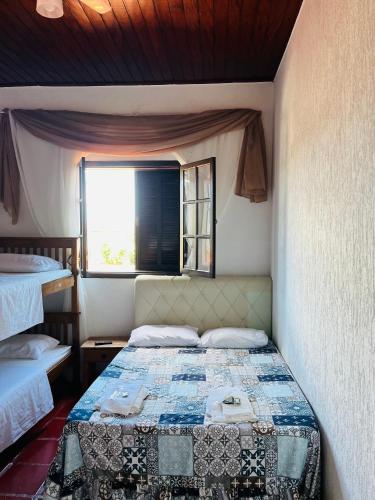 a bedroom with two beds and a window at Hostel Pé na Areia in Itanhaém