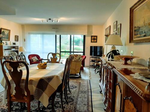 un salon avec une table et une cuisine dans l'établissement Le jardin de la Baie-face plage du Trez & thalasso, à Bénodet