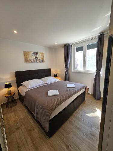 a bedroom with a large bed and two windows at La Selina Nin in Nin