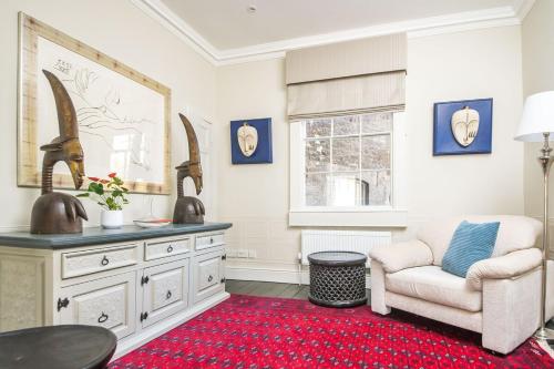 a living room with a chair and a table at Bespoke Central Town House in Bath