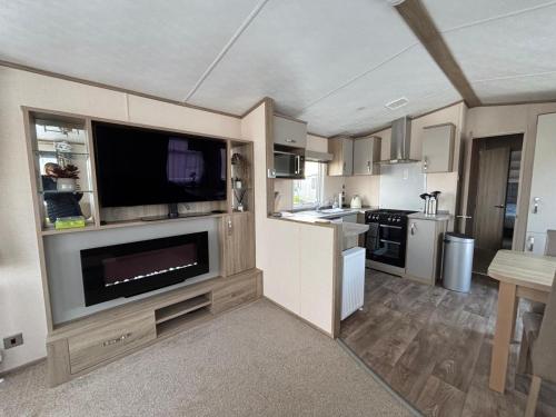 a kitchen with a flat screen tv and a living room at Seaview Holiday Rentals - Bluewater in Whitstable