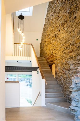 a staircase in a house with a stone wall at Le Petit Fief in Couvin