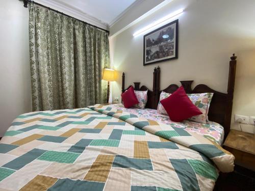 a bedroom with a large bed with red pillows at Hotel Signature Villa in Jodhpur