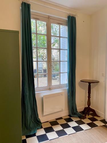 Cette chambre dispose d'une fenêtre avec des rideaux verts et d'un sol en damier. dans l'établissement Dépendance calme avec jardin au coeur de Bordeaux, à Bordeaux