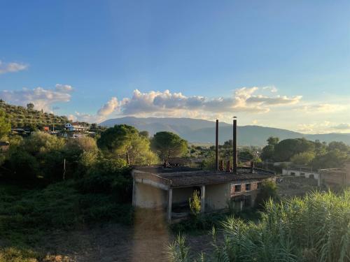 an old building in a field with mountains in the background at Guesthouse RAMAJ in Perondi