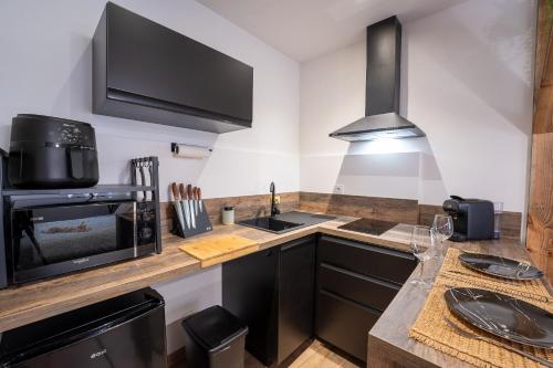 a kitchen with a counter with a microwave and a sink at Le Refuge, studio cosy centre de libourne in Libourne