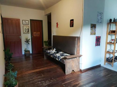 a living room with a bench in the corner of a room at Casa Antiga em OP in Ouro Preto