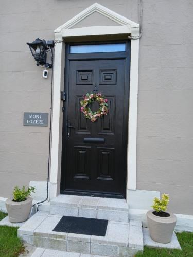 a black door with a wreath on it at A Classic Donegal Townhouse in Donegal