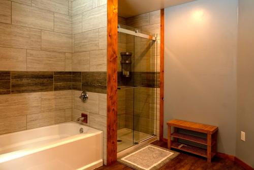 a bathroom with a tub and a glass shower at Stu Dog's House in Silverton