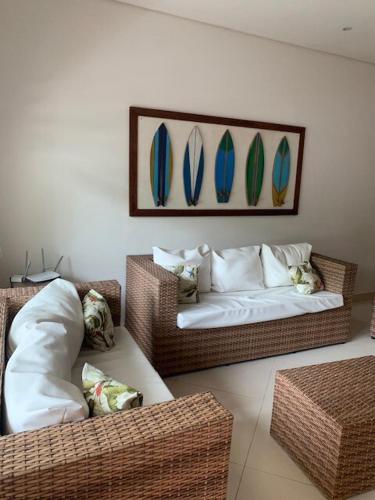 two wicker chairs and a couch in a living room at Casa em Juquehy com muita natureza in São Sebastião