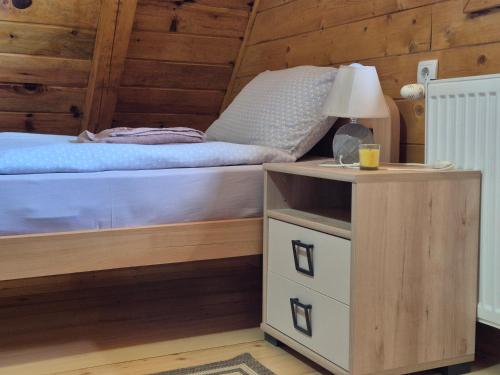 a bedroom with a bed and a table with a lamp at Vikendica Rile in Sekulić 