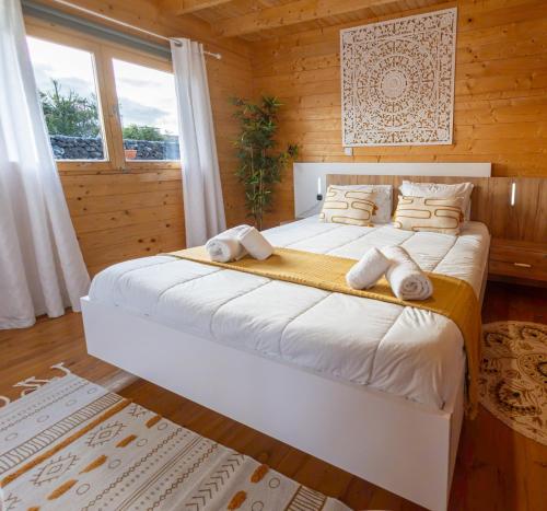 ein Schlafzimmer mit einem großen Bett in einem Holzzimmer in der Unterkunft Mountain Wood Village in Madalena