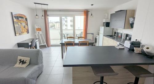 une cuisine et un salon avec une table et un canapé dans l'établissement L'Esplanade, à Besançon