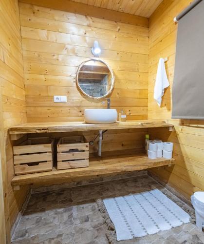 a wooden bathroom with a sink and a mirror at Mountain Wood Village in Madalena