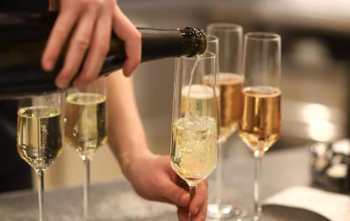 a person pouring champagne into a group of wine glasses at Hotel Am Hirschhorn - Wellness - Spa - and more in Wilgartswiesen