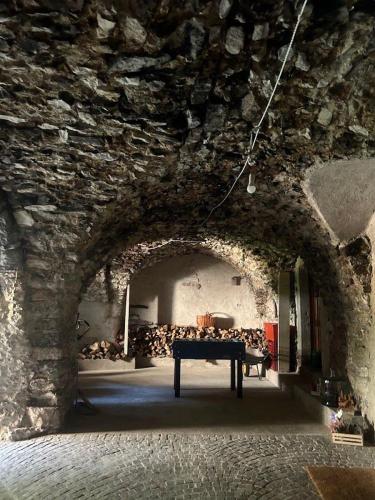 a room with a table in a stone wall at B&B Ai Castagni in Tenno