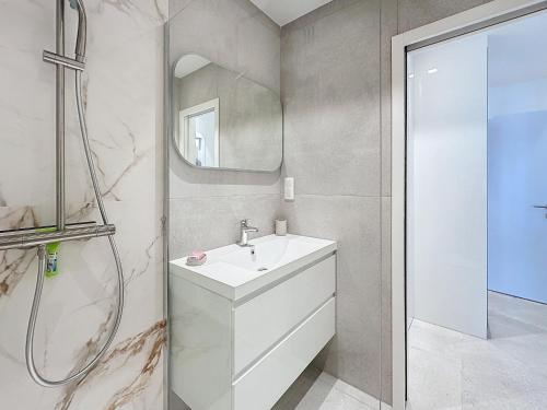 une salle de bain blanche avec un lavabo et une douche dans l'établissement 39m2 Croisette, terrasse, vue mer, garage, à Cannes