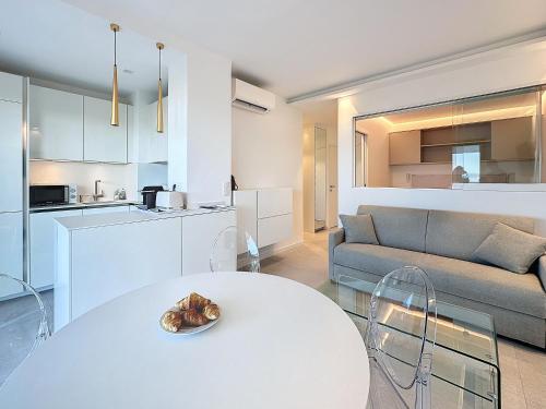 un salon avec une table blanche et un canapé dans l'établissement 39m2 Croisette, terrasse, vue mer, garage, à Cannes