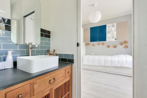 une salle de bain avec un lavabo et un miroir dans l'établissement Maison de la Source - Piscine chauffée, proche plage du Betey, à Andernos-les-Bains