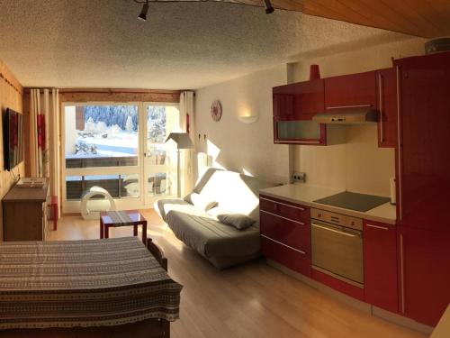 Il dispose d'une cuisine et d'un salon avec un canapé et une table. dans l'établissement Magnifique 2 pièces avec coin nuit, balcons sud, au pied des pistes de Corrençon-en-Vercors - FR-1-515-17, à Corrençon-en-Vercors