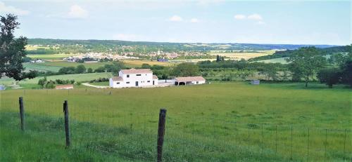 un champ avec une clôture et un bâtiment blanc au loin dans l'établissement Magnifique villa avec piscine classée 5 étoiles, à Vouneuil-sur-Vienne