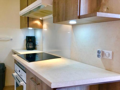 une cuisine avec un comptoir blanc et des placards en bois dans l'établissement Appartement 3 pièces, balcon sud, pied des pistes, 6 couchages, parking proche - FR-1-515-32, à Villard-de-Lans