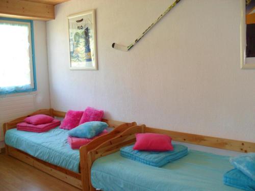 two beds in a room with pink and blue pillows at Charmant 3 pièces à Villard-de-Lans, proche centre et pistes - FR-1-515-57 in Villard-de-Lans