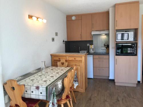 - une petite cuisine avec une table et un comptoir dans l'établissement Studio cabine au pied des pistes de Corrençon-en-Vercors - FR-1-515-70, à Corrençon-en-Vercors