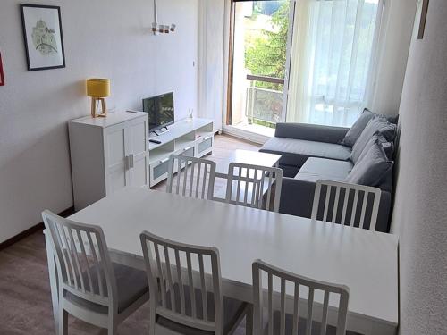 un salon avec une table, des chaises et un canapé dans l'établissement Appartement rénové 43m² avec 2 balcons, parking gratuit et Wi-Fi, à Villard-de-Lans - FR-1-515-66, à Villard-de-Lans