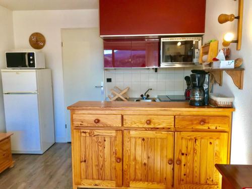 - une cuisine avec une armoire en bois et un évier dans l'établissement Studio cabine 33m² avec balcon au centre du village - FR-1-515-68, à Villard-de-Lans