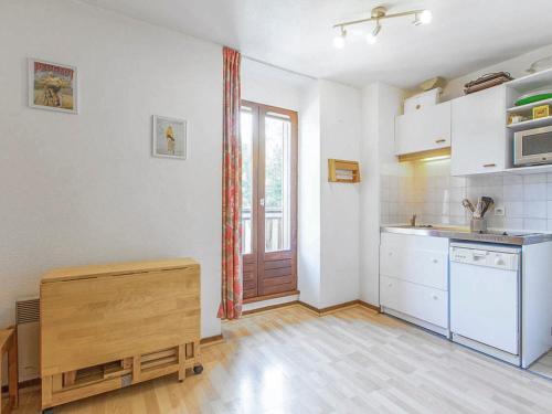 une cuisine avec des armoires blanches et un plancher en bois dans l'établissement Appartement cosy avec parking privé et balcon à 5 min du centre de Villard-de-Lans - FR-1-515-94, à Villard-de-Lans