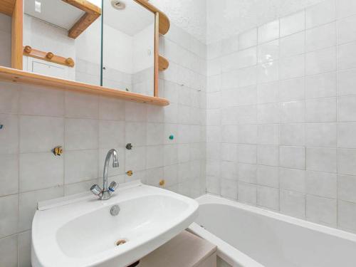 une salle de bain blanche avec un lavabo et une baignoire dans l'établissement Appartement cosy avec parking privé et balcon à 5 min du centre de Villard-de-Lans - FR-1-515-94, à Villard-de-Lans