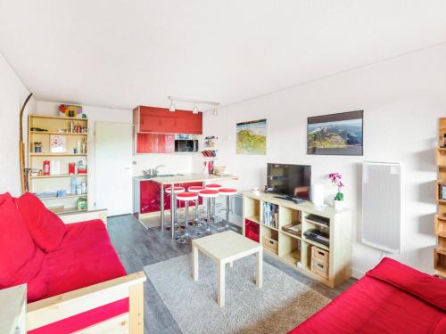 - un salon doté d'un mobilier rouge et d'un canapé rouge dans l'établissement Studio cabine rénové avec parking couvert et casier à ski, proche centre - FR-1-515-96, à Villard-de-Lans
