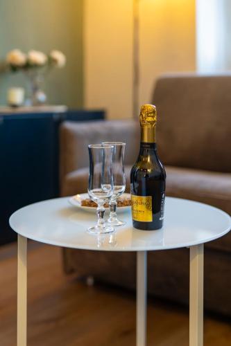 a bottle of wine and two glasses on a table at Business House in Costa Volpino