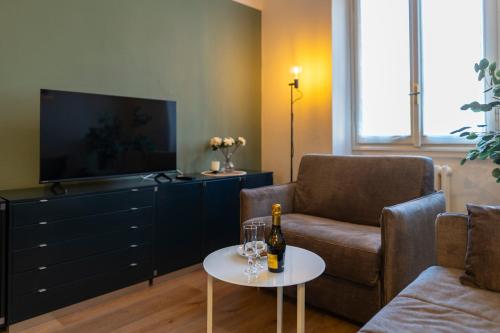 a living room with a couch and a bottle of wine on a table at Business House in Costa Volpino