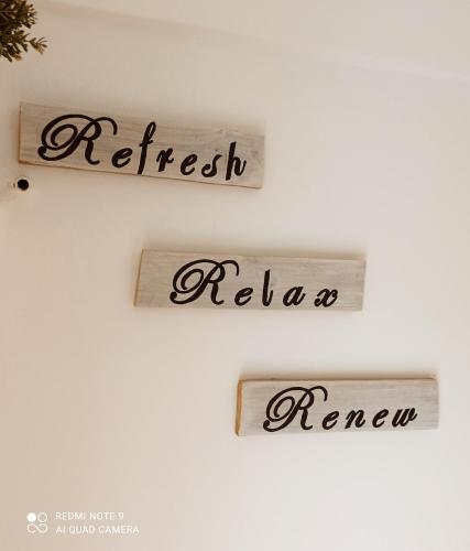 three signs on a white wall with the words first africanemiaemia renew at Blue Seaview Appartments in Paphos City