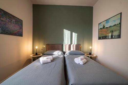 two twin beds in a bedroom with two lamps at Business House in Costa Volpino